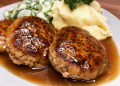 Fleischpflanzerl mit Kartoffelpüree und Gurkensalat.